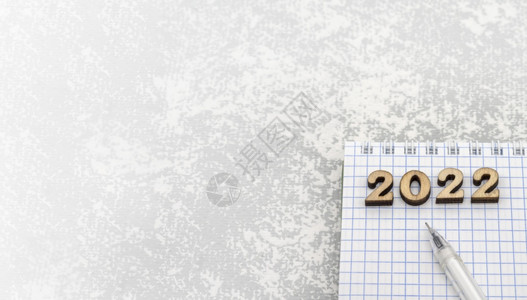 202220年灰色木制数字的笔记本和一张空白纸页和笔本桌边的Wooden号码为20年一张空白纸单和根圆珠笔最后期限挑战木头背景