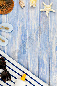 最佳空白的小样海滩毛巾太阳墨镜海壳贝尾鱼的顶端视图其背景为面糊蓝木板底并附有空间模拟文本板复制件图片
