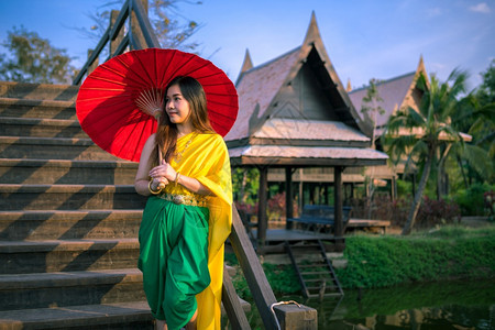 漂亮的年轻泰国妇女以伞式传统风格装饰泰国妇女裙子图片