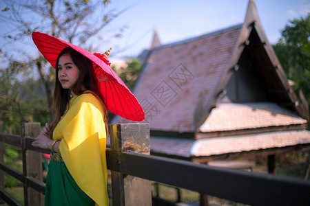 敷料泰国妇女以伞式传统风格装饰泰国妇女亚洲人红色的图片