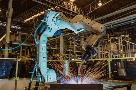 机器人正在生产线中焊接机械图片