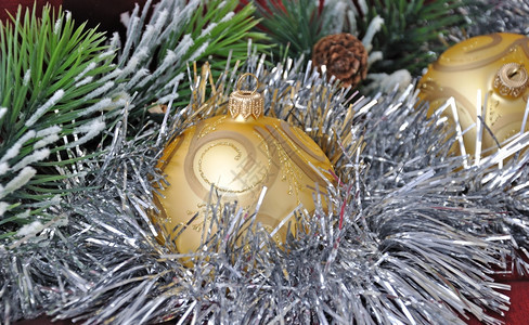 装饰品圣诞球在松树枝和锥壳的锡赛背景之下举行季节圣诞图片