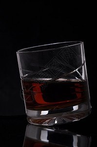 橙白兰地黑色背景的美丽威士忌杯子酒图片