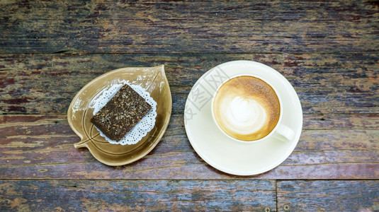 木制桌上的热咖啡和巧克力蛋糕卡布奇诺美食早晨图片