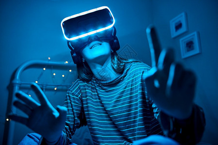 人们夜里穿着虚拟现实耳机的床间小女生在家乐趣图片