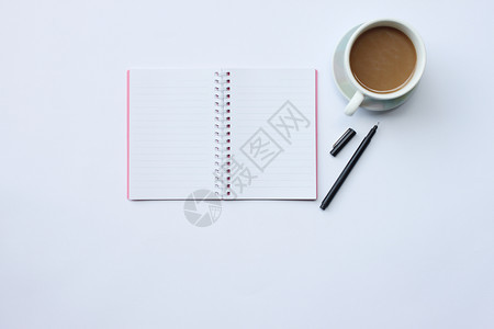 工作区笔记本和咖啡杯放在办公室的白桌子上并有复制你工作中的概念空间您桌面图片