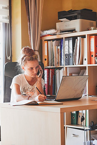 案子人们书架在家工作使用便携式计算机坐在家庭办公室桌前的年轻妇女Candid人真实时刻情况等图片