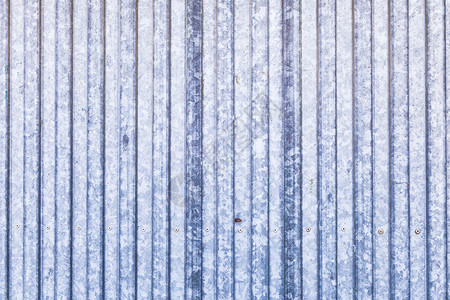 划伤老的蓝色生锈金属门带白建筑的图片