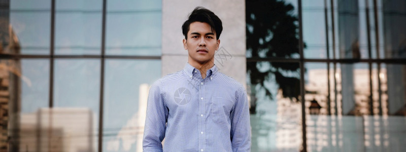 努力相机工作年轻自信的亚洲青年企业家在城市中站立一看摄影机图片