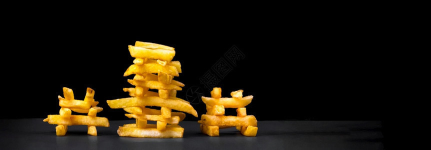 艺术以黑背景金字塔形式呈现的三条开胃薯象征餐厅图片