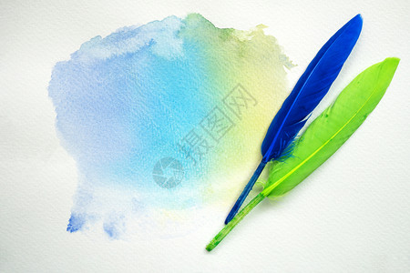 黄色的绘画蓝白纸上含有羽毛的抽象彩色水图片