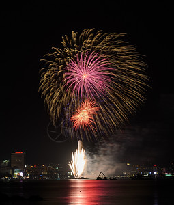 快乐的发光城市泰国Pattaya海岸城市风景背的多彩烟火图片