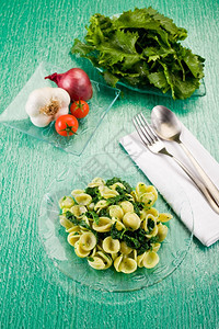 配料用具意大利地区菜在绿玻璃桌上有意大利面食和萝卜蒜图片
