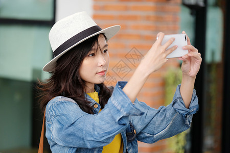 城市户外背景使用智能手机的年轻亚洲女有技术的户外人士电话上的生活方式等聪明的应用程序社会图片
