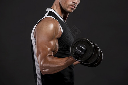 健身房肌肉发达人身穿工作室举起的重量在白色背景上被孤立强的图片