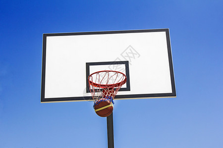 胜利篮球在蓝天背景中击篮子木板成功图片