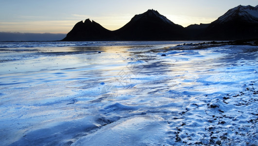 海滩黄昏水冬季日落时冰雪在东峡湾的原形成图片