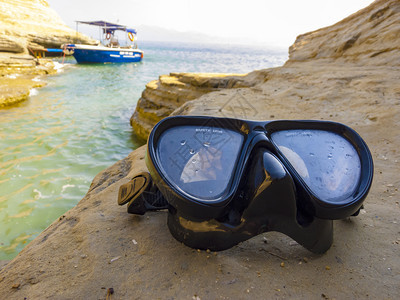 蓝色的靠近用于在海岩石上进行水肺潜的面罩用于在近海岩石上进行水肺潜的面罩支撑图片