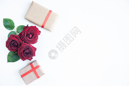 束平躺背景花卉图案情人节恋主题红玫瑰和白色背景上带丝的礼物与世隔绝包颜色图片