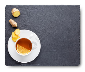 材料棕色的热在黑板上加柠檬和姜根的茶在黑板上加柠檬和姜根的茶孤立在白背景上的黑板图片