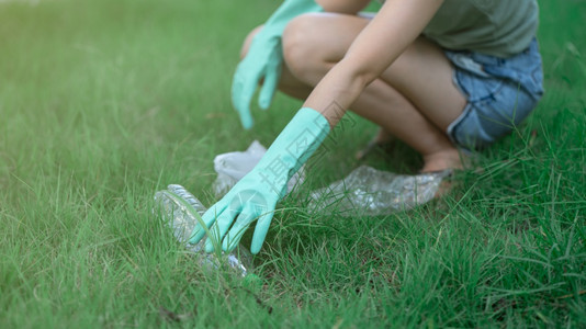 妇女手把塑料废物放在公园的黑袋中脏废物在她的手中污染减少黑色的图片