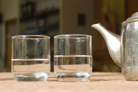 桌上有两个杯子和钢茶壶目的白色干净图片