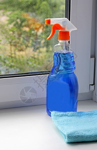 相片用一个透明瓶子洗窗户站在台上对着清洁布旁边的肮脏玻璃来遮挡窗台和洗衣玻璃的工具纯度作图片
