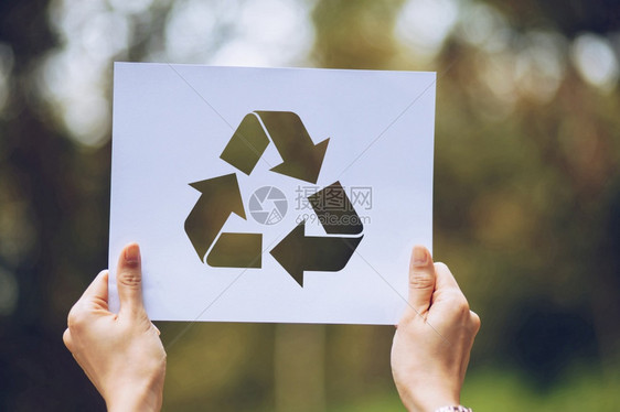 以手握剪切的纸张循环展示保存世界生态概念和环境保护用手持纸张循环显示工艺城市抽象的图片