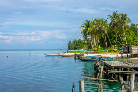 传统的印度尼西亚在热带岛屿海岸的几艘船和木棚上架设了几条小船和一个木棚该热带岛屿大海至村庄边缘的地平线旧码头和船只老的水图片