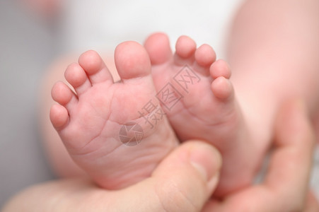母亲双手握着新生儿小脚大型闭合选择焦点大型关头选择焦点产假星光脚趾图片