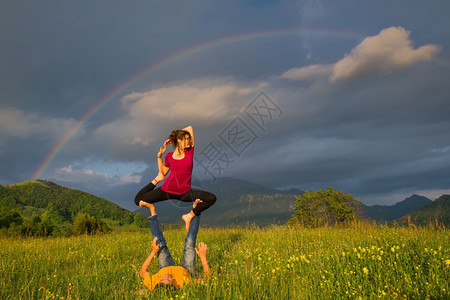 福利浓度男人Acroyoga女孩在山上的位置是男本背景是彩虹图片