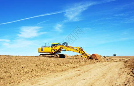 犁田中的黄色挖掘机土方农业力量图片