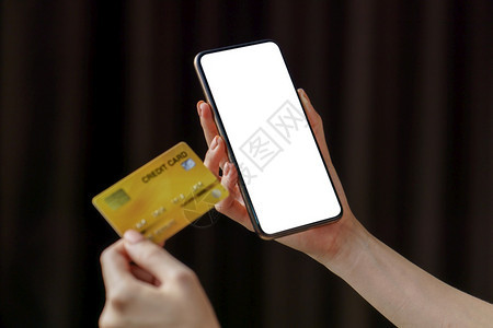 在线支付妇女通过手机智能电话用信卡付款进行网上购物在付费妇女以手机智能电话方式购买信用卡电子的数据连接图片