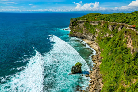 印度尼西亚海洋上阳光明媚的天气和地平线上的云层沿着阿尔布山顶的岩石热带海岸沿途道落基热带海岸和阿尔布与的预兆海岸线最佳多岩石的图片
