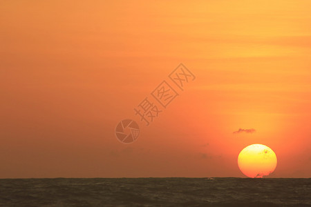 黄昏海滩太阳从中升起浪图片