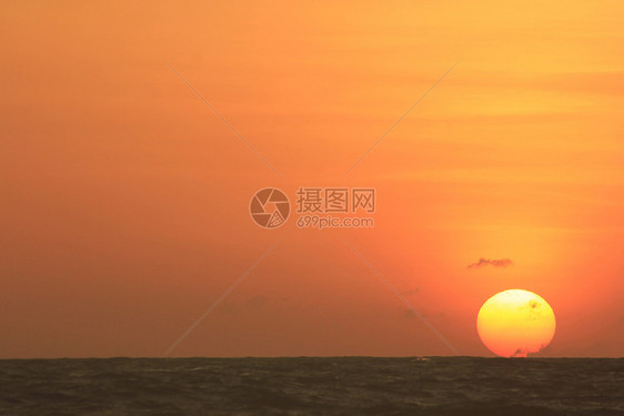 黄昏海滩太阳从中升起浪图片