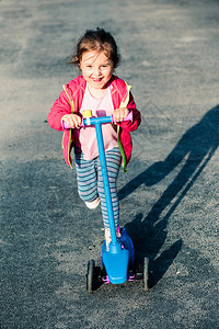 活动童年可爱的小女孩在骑摩托车户外玩耍时得开心加速度图片