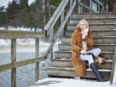 套衫夹克身着冬季服装的时成年妇女坐在楼梯上农村一幕寒冷的图片