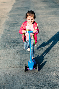 美丽的可爱小女孩在骑摩托车户外玩耍时得开心骑术乐趣图片
