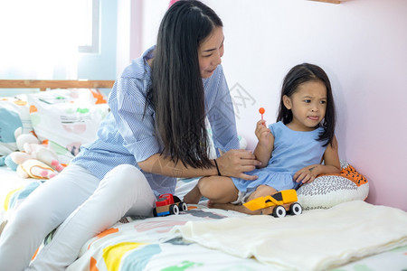 快乐的女人和小孩一起吃甜的微笑亚洲女士图片