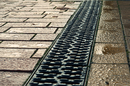 人行道上的排水和铺路人行道路石头金属钢炉排水城市雨洪结石图片