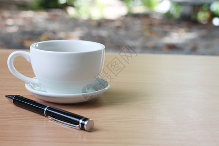 咖啡杯和笔放在桌上图片