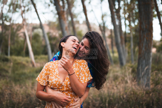 女士两名身穿裙子的年轻妇女在森林中行走微笑夏天图片