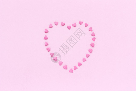 粉红色糖果的心洒在形上位于柔和的粉红色背景中心概念Valentinersquos卡顶视图复制文本空间平坦的爱甜图片