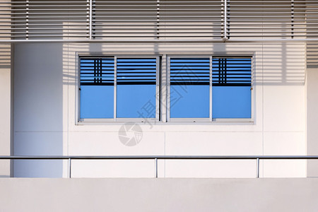 防锈的具体正面玻璃窗表的蓝色天空反射不锈钢皮和现代白色办公大楼阳台均以现代风格在玻璃窗上图片