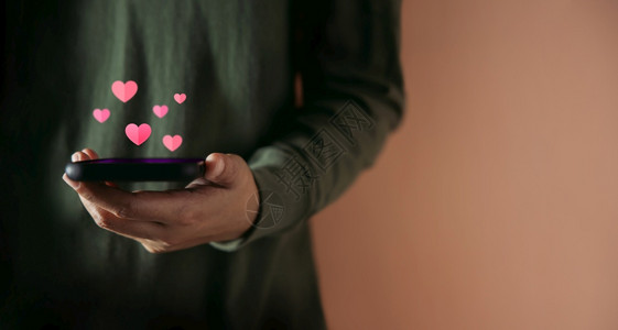 分享社会的拥有智能手机阅读浪漫爱情讯息的人在移动电话顶端视图上漂浮着的概念心图标用于阅读浪漫爱情信息infowhatsthis情图片
