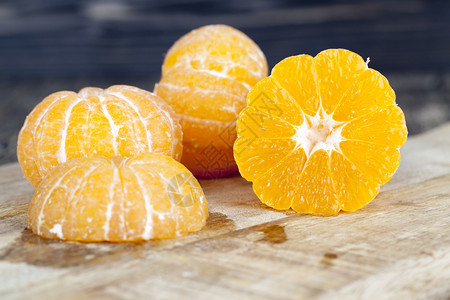 剪切板上的剥皮曼达林果汁扩散到切成橘子的板上剪下自然放图片