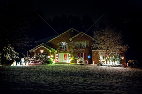 发光的童话冬天晚上为圣诞节装饰的房子晚上为圣诞节装饰的房子被雪覆盖图片