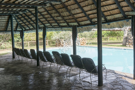 假期太阳椅子非洲南部有稻草屋顶和座位的热带游泳池非洲南部图片
