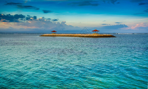 目的地云长椅日落时分在开阔水域的巴厘岛凉亭图片